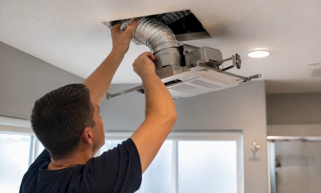 Contractor installing bathroom exhaust fan duct
