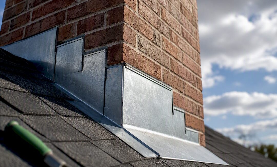 Chimney flashing meeting a shingled roof