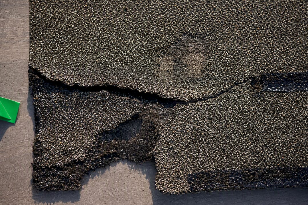 Close-up of fractured asphalt roof shingle