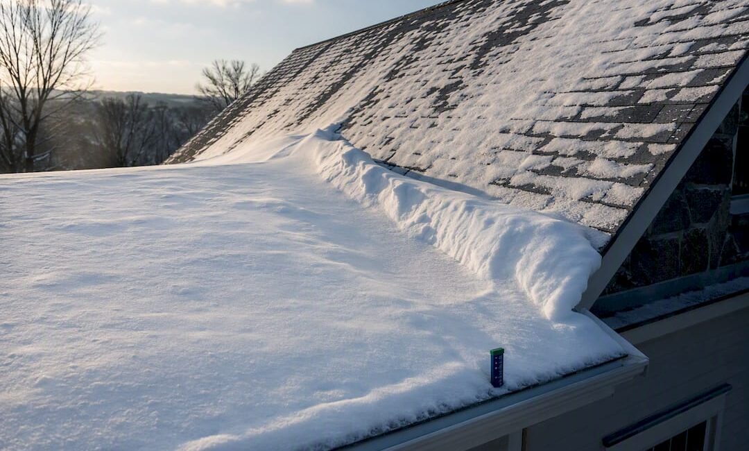 Snow drift accumulating beside taller roof section