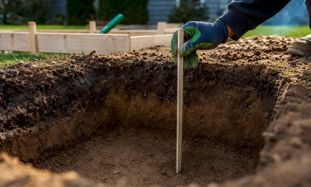 Contractor checking residential deck footing depth