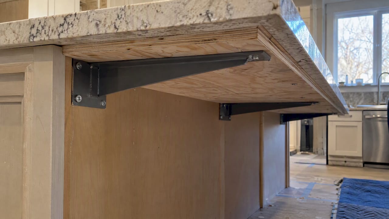 Steel bracket supporting a stone island overhang