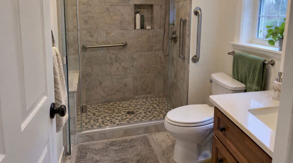 Bathroom shower with grab bars and textured floor