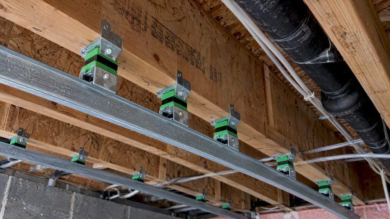 Sound isolation clips beneath exposed ceiling joists