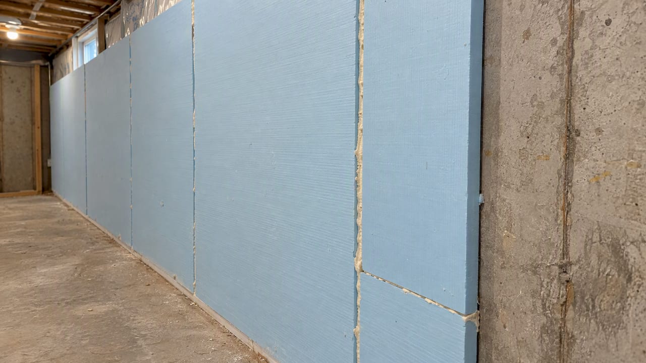 Foam board insulation against basement foundation wall