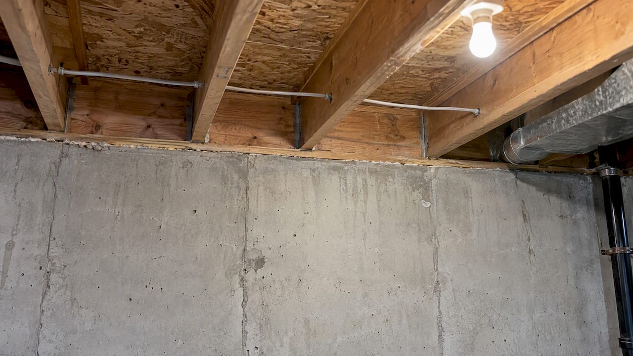 Exposed rim joist above a concrete foundation